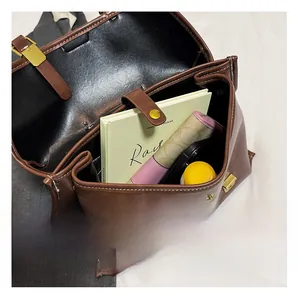 Close-up of brown retro backpack interior showing spacious storage for books and phone