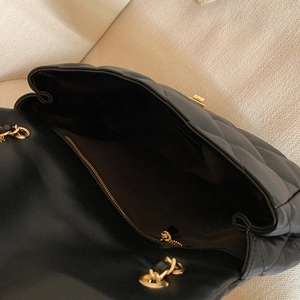 Black quilted crossbody bag with gold chain strap and spacious interior compartment
