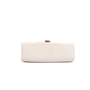 Detail view of the beige leather handbag bottom with fine stitching and golden metal lock