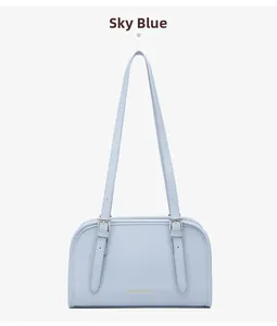 Detailed view of sky blue leather shoulder bag with silver buckles and logo print
