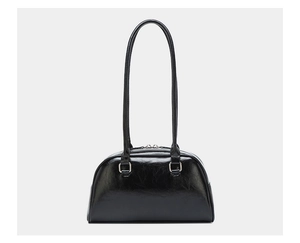 Close-up of black oil wax leather bowling bag with vintage glossy finish and silver buckle