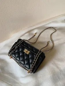 Gros plan sur les coutures matelassées noires et le fermoir doré du sac à bandoulière