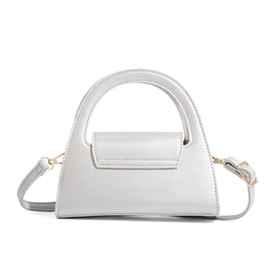 Detail of light gray semi-circle handbag with fine leather texture and gold hardware