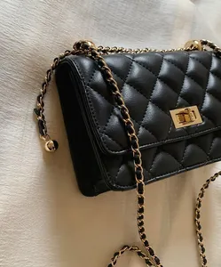Détail du sac matelassé noir avec bandoulière en chaîne dorée et fermoir en métal