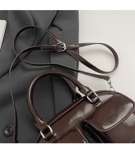 Detail of adjustable shoulder strap and silver buckles on vintage brown oil wax leather bag