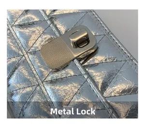 Detail of silver metallic quilted bag featuring a rectangular textured hardware lock