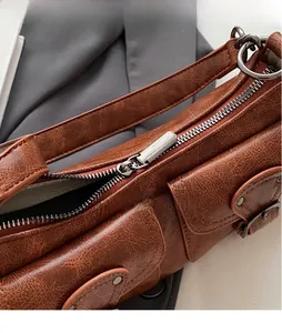 Close-up of polished silver metal zipper on vintage brown cracked leather shoulder bag