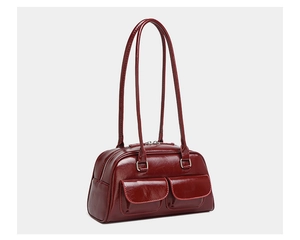 Macro shot of dark burgundy oil-wax leather handbag with functional front flap pockets