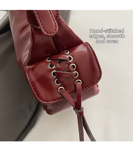 Detailansicht der burgunderroten Ledertasche mit seitlicher Schnürung und Silberösen