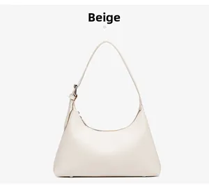 Detail view of the beige crescent shoulder bag with adjustable silver metal buckle