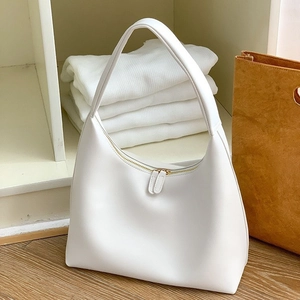 Minimalistische weiße Halbmond-Tasche aus Leder mit Gold-Reißverschluss auf Holzboden