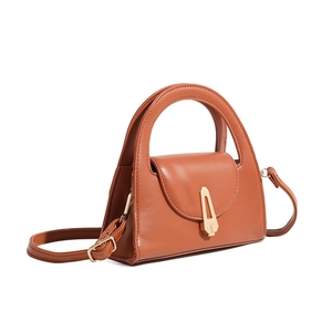 Side view of a caramel semi-circle crossbody bag with golden geometric lock detail