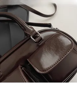 Detailed macro view of silver metal hardware and shiny oil wax leather texture on bag