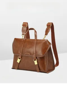 Detail of vintage brown leather convertible backpack with gold buckles and English style