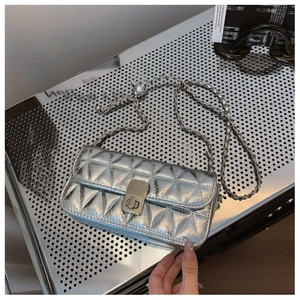 Detail of silver quilted leather bag with metallic chain and rectangular twist lock closure