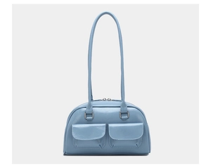 Detail of light blue oil wax leather handbag showing dual front flap pockets and silver hardware