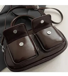 Close-up of retro oil wax leather bag featuring silver magnetic buckles and dual front pockets
