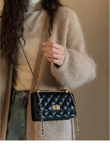 Vue latérale d'un sac bandoulière matelassé noir avec chaîne dorée sur le mannequin