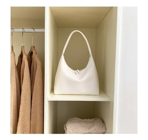 Nahaufnahme der minimalistischen cremefarbenen Hobo-Tasche mit glatter Lederstruktur und Reißverschluss