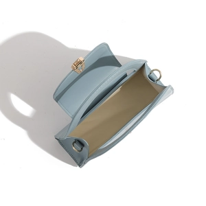 Close-up showing the spacious beige interior and gold lock of the light blue handbag