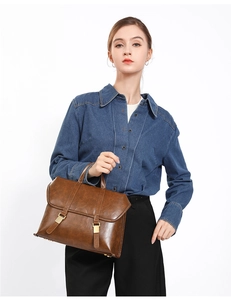 Detailed view of a vintage brown leather satchel featuring classic dual buckle straps