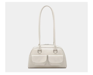 Detail view of cream white bowling bag with dual front flap pockets and silver hardware