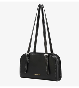 Detail view of black leather shoulder bag with white stitching and silver buckles