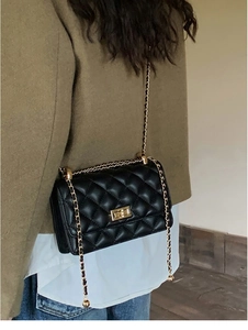 Vue détaillée du sac matelassé noir à chaîne avec fermoir doré porté par un mannequin