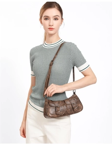 Model wearing dark brown vintage shoulder bag with double front buckle pockets