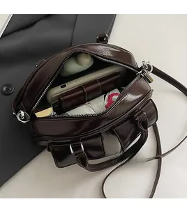 Spacious interior of retro brown leather bag showing capacity for phone and wallet