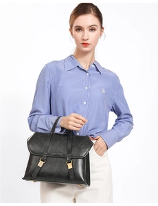 Close-up of black leather briefcase bag with white stitching and gold hardware buckle