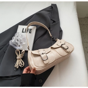 Detail of beige crescent bag with faux leather texture on grey suit jacket