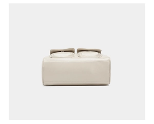 Detail of off-white oiled leather handbag showing side pockets and silver button closure