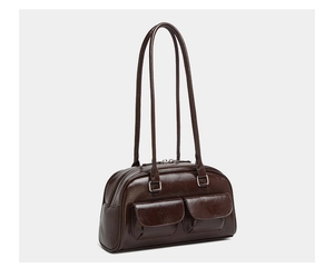 Close-up of brown oiled leather shoulder bag featuring dual front pockets and glossy finish