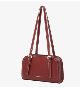Detailed view of burgundy vintage bowling bag with white contrast stitching and gold logo