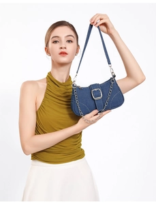 Gros plan d'un sac à bandoulière en denim bleu avec boucle argentée et chaîne chic