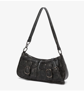 Detail of black vintage motorcycle bag featuring aged faux leather and double front pockets