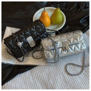 Detail of black and silver quilted handbags with chain straps and metallic locks
