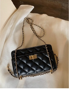 Détail du petit sac noir matelassé avec fermoir doré et bandoulière en chaîne