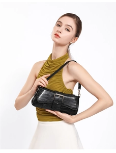 Detail of black stone-pattern baguette bag with metallic buckle worn by a model