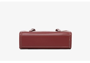 Detailed bottom view of dark red leather handbag with white contrast stitching accents