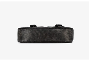 Detailed bottom view of a vintage black leather crossbody bag with textured finish