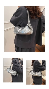 Detail view of silver shoulder bag showing metallic leather texture and fringe tassel