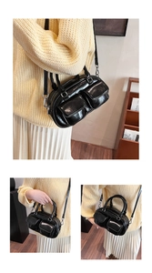 Close-up of black oil-wax leather Boston bag with dual pockets and silver zippers