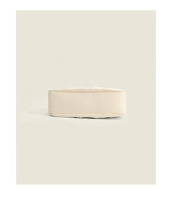 Flat bottom detail of a cream pleated cloud bag made of smooth premium faux leather