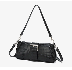 Detail shot of black crocodile embossed texture with silver square metal buckle on bag
