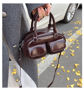 Detail of vintage dark brown oil wax leather Boston bag with dual buckled front pockets