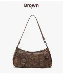 Close-up of vintage brown biker bag with metallic buckles and distressed leather texture
