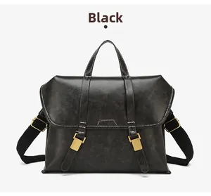 Detail of vintage black leather briefcase with adjustable shoulder strap and gold hardware