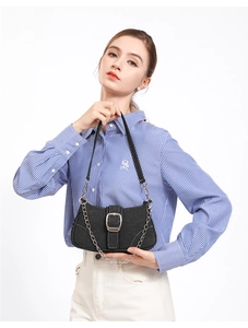 Détail du sac bandoulière en denim noir avec boucle argentée et chaîne élégante